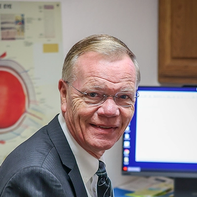 Eye Doctor Larry G. Obie Smiling In Exam Room